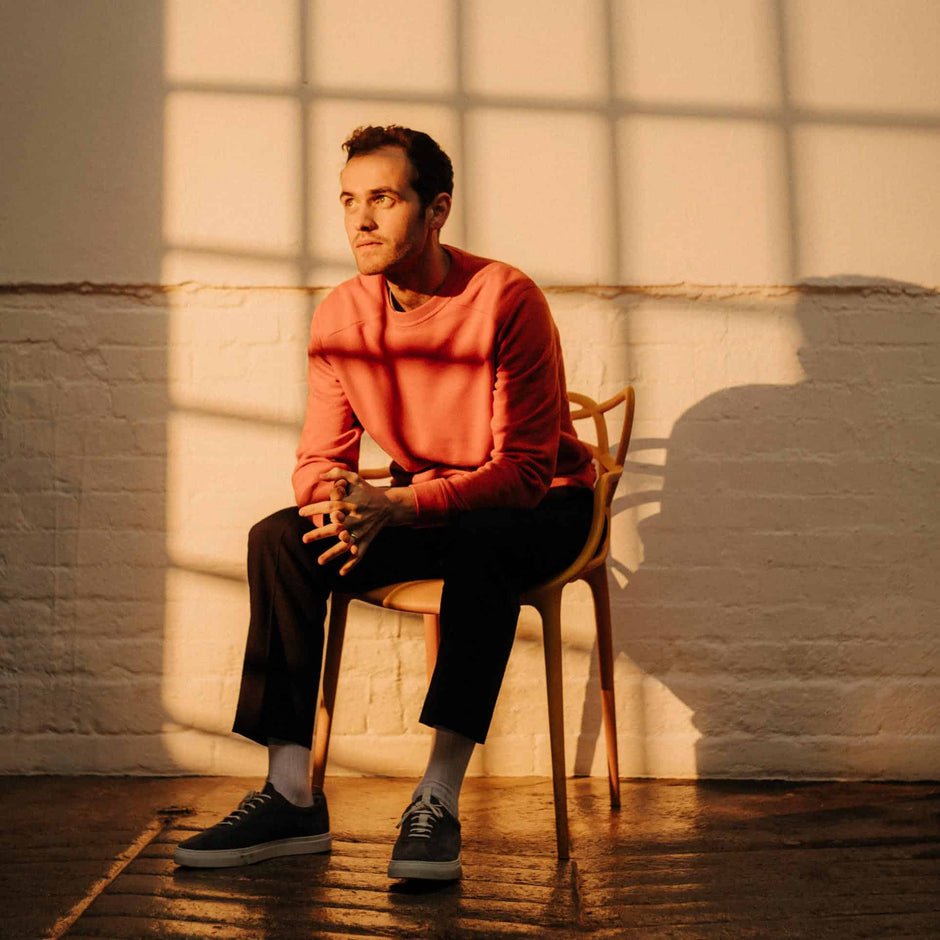 portrait of JORDAN RAKEI sitting on a chair 