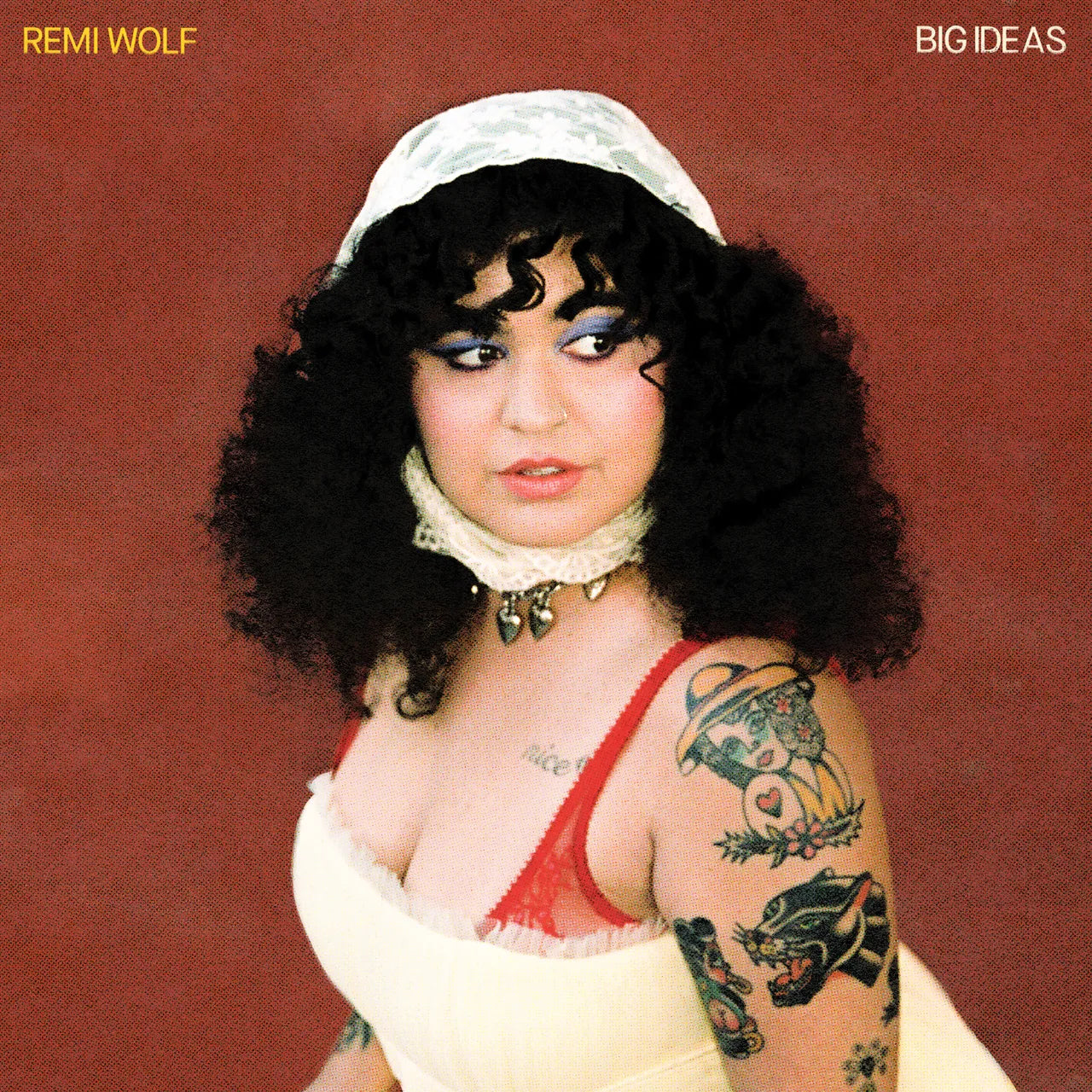 A picture of Remi Wolf with her tatoos and hair scarf on her head