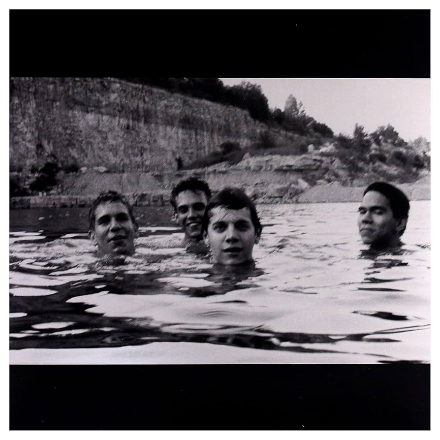 Slint - Spiderland Vinyl Record

Black and white photo of four people partially submerged in water with a rocky shoreline in the background.