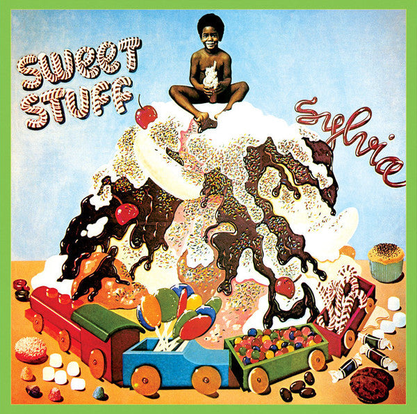 a child sitting on top of a large cake